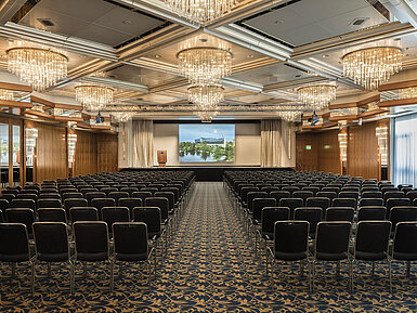 Eleganter Veranstaltungssaal mit Kristalllüstern, Reihenbestuhlung und großer Bühne im Maritim Hotel Hannover.