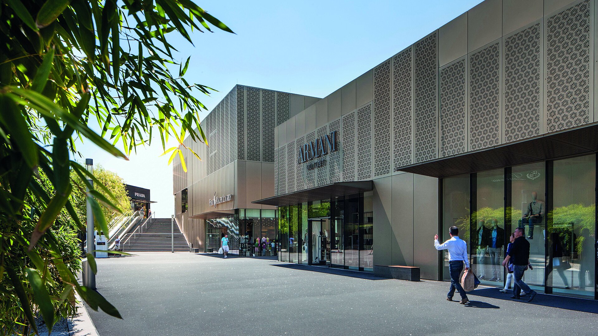 Armani Outlet Store mit moderner Fassade, Einkaufsbereich und Besuchern bei Sonnenschein