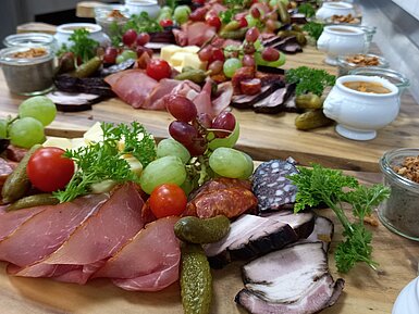 Herzhaft belegte Brotzeitplatte mit Wurst, Käse, Trauben und Dips in der Maritim Alm Stuttgart