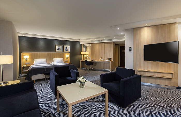 Geräumige Junior-Suite im Maritim Hotel Würzburg mit Doppelbett, Sitzbereich und modernem Design