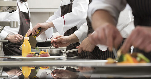 Köche bereiten Gourmetgerichte in der Küche der Orangerie im Maritim Seehotel Timmendorfer Strand zu.