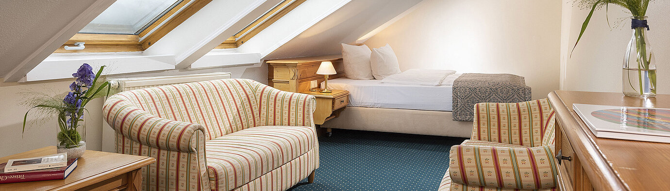 Charmantes Zimmer mit Dachfenstern, Sofa und Sessel im Maritim Hotel Titisee