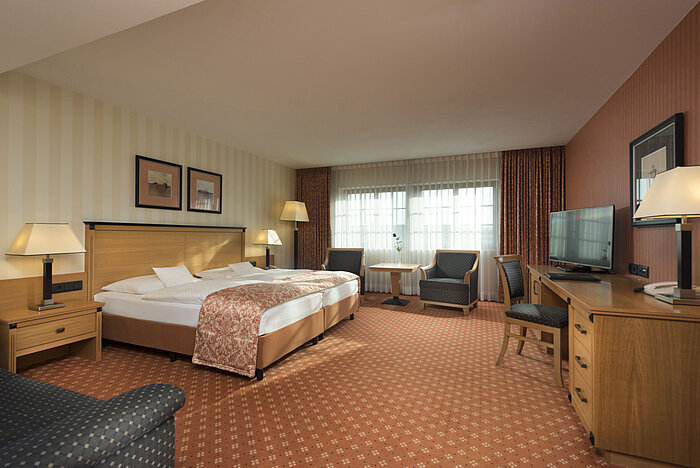 Classic Zimmer im Maritim Hotel Dresden mit Doppelbett, Sitzbereich und klassischem Dekor.