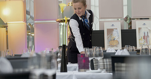 Servicekraft deckt stilvoll den Tisch im Restaurant des Maritim Hotel München