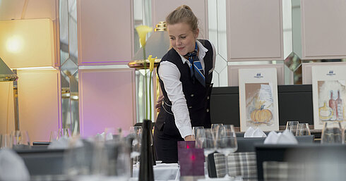 Maritim Tagungsservice Servicekraft deckt stilvoll den Tisch im Restaurant des Maritim Hotel München