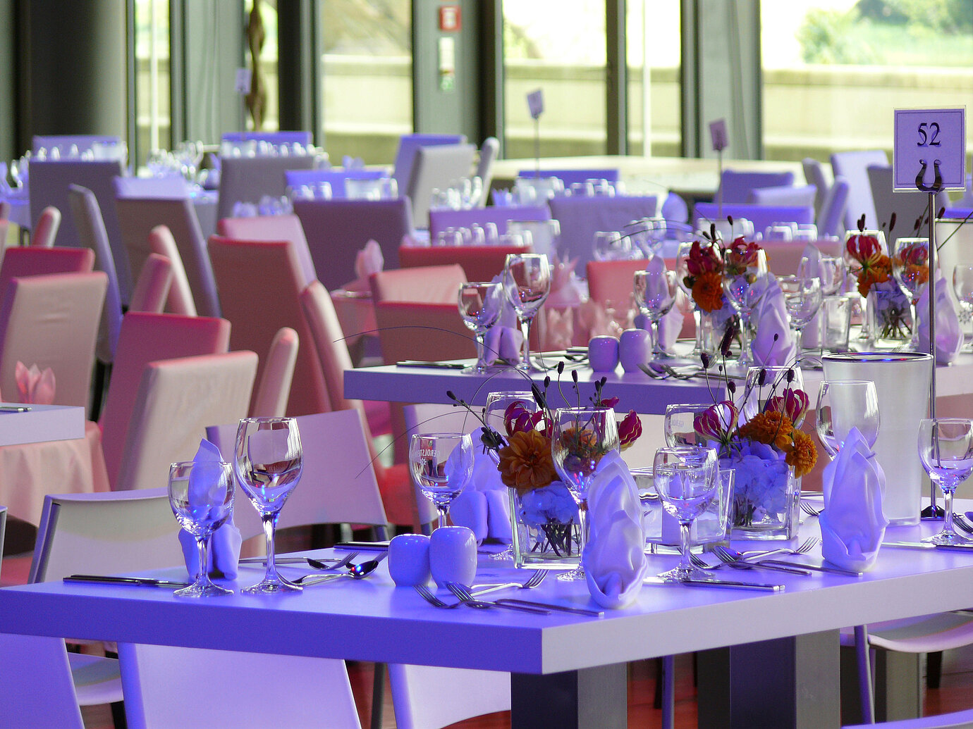 Detailansicht von elegant gedeckten Tischen mit Blumenarrangements im Veranstaltungsraum des Maritim Hotel Dresden.