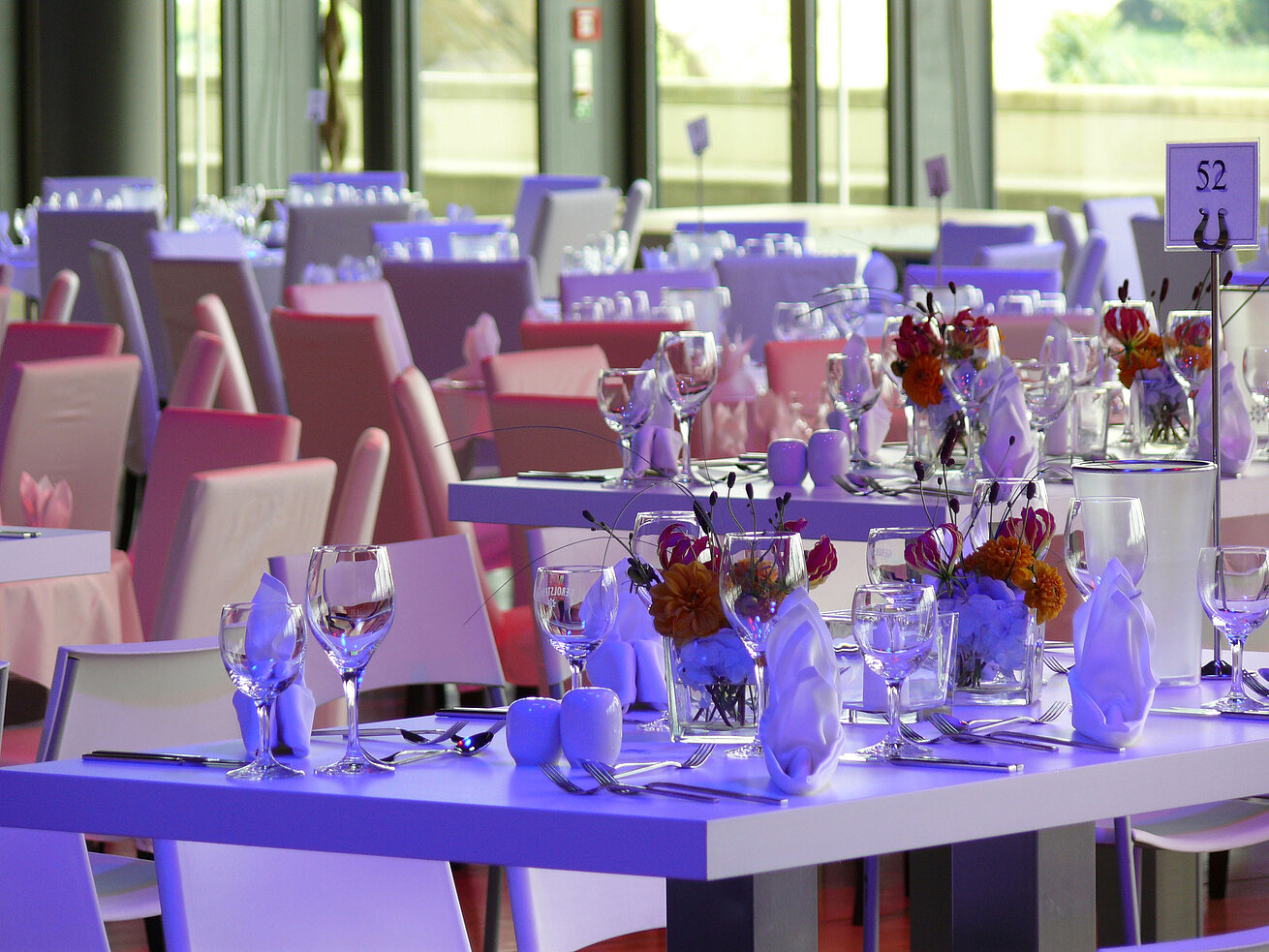 Detailansicht von elegant gedeckten Tischen mit Blumenarrangements im Veranstaltungsraum des Maritim Hotel Dresden.