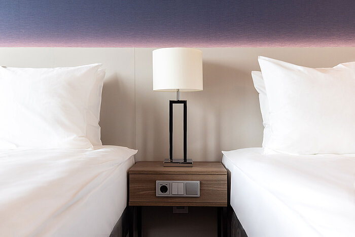 Nachttisch mit Lampe zwischen zwei Betten im Maritim Hotel Amsterdam