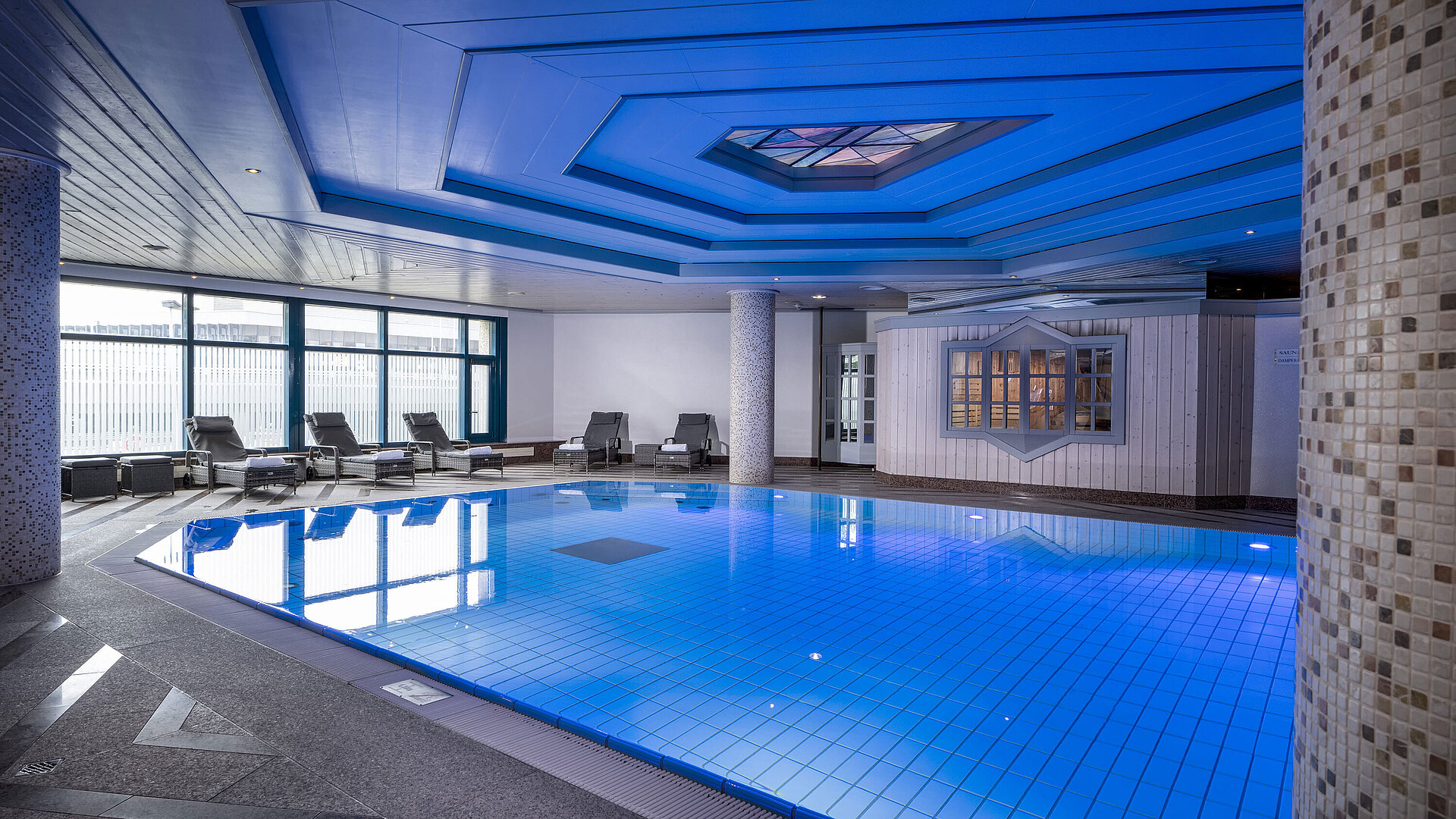 Schwimmbad Innenpool im Maritim Hotel Hannover mit Liegestühlen und moderner Beleuchtung.