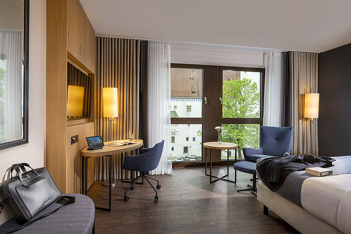 Modern eingerichtetes Hotelzimmer im Maritim Hotel Ingolstadt mit Schreibtisch und Blick auf die Stadt.