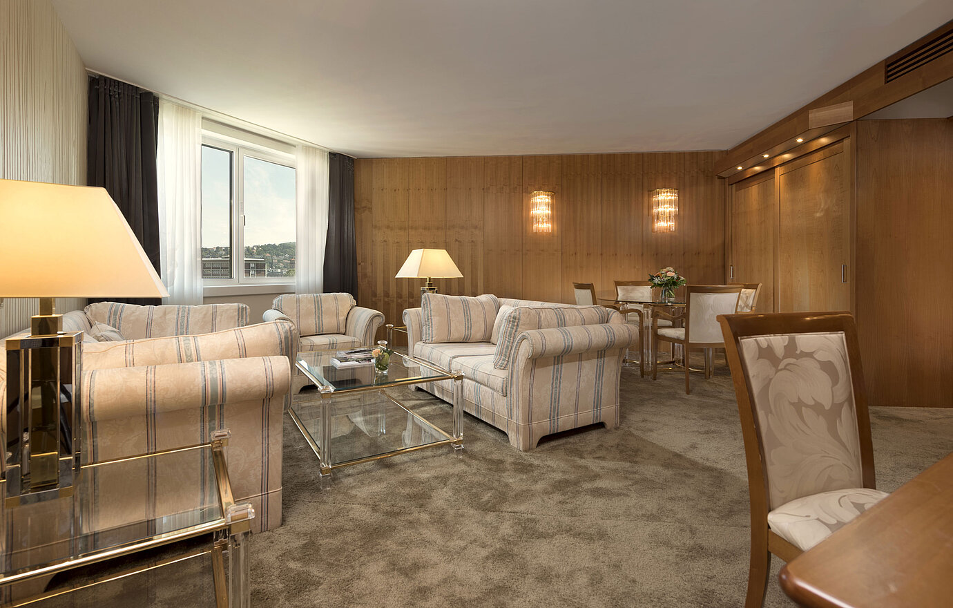 Geräumiges Wohnzimmer mit großem Fenster und Sitzgruppe im Maritim Hotel Stuttgart