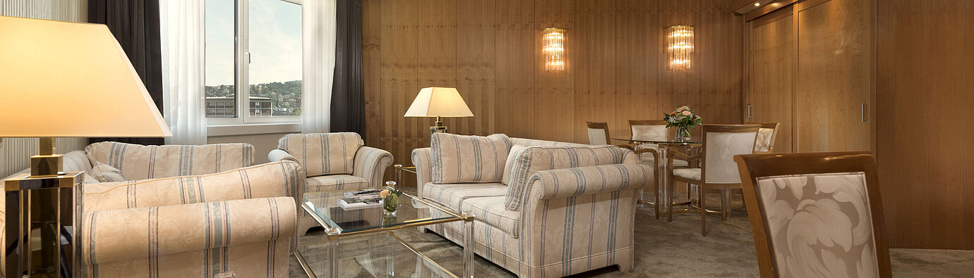 Classic Suite Geräumiges Wohnzimmer mit großem Fenster und Sitzgruppe im Maritim Hotel Stuttgart