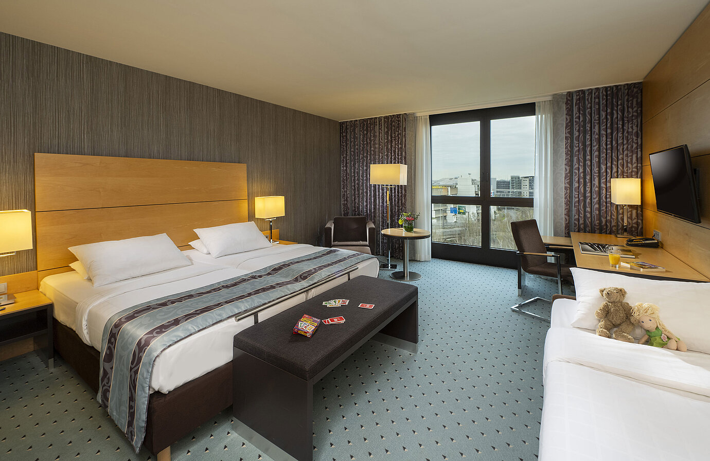 Comfort Familienzimmer im Maritim Hotel Düsseldorf mit großem Doppelbett, Einzelbett, Spielkarten und Plüschtieren für Kinder
