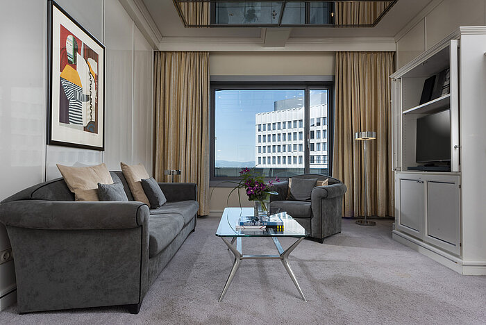 Geräumige Executive Suite im Maritim Hotel Frankfurt mit eleganter Einrichtung, gemütlicher Sitzecke und Panoramafenster.