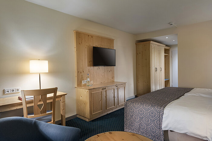 Zimmer im Maritim TitiseeHotel mit Holzmöbeln, Schreibtisch und TV