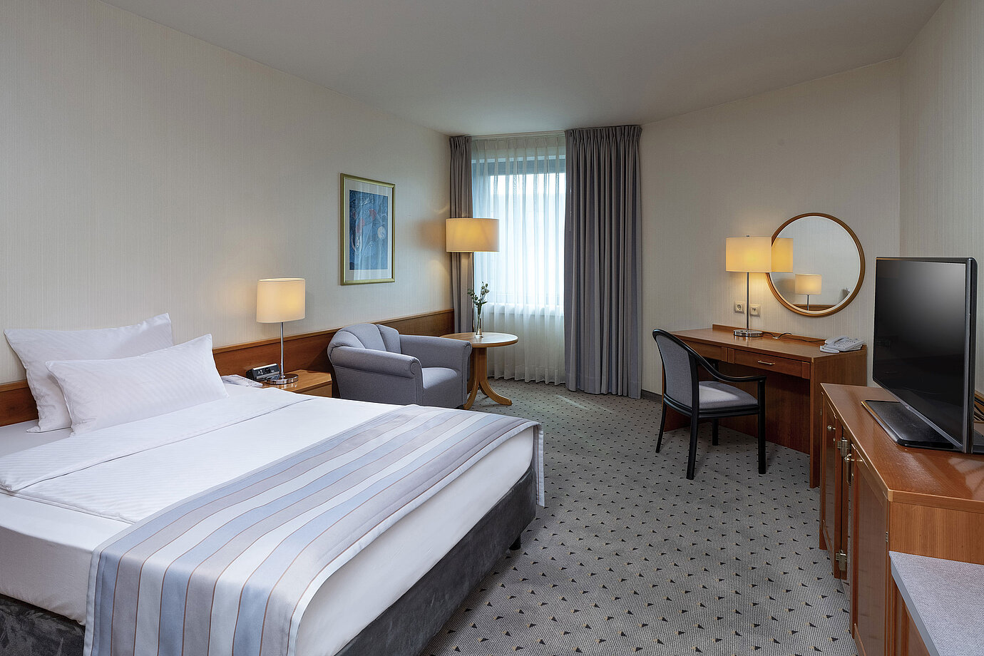 Gemütliches Classic Zimmer mit großem Bett, Schreibtisch, TV und eleganter Einrichtung im Maritim Hotel Hannover.