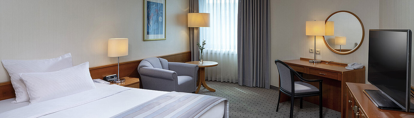 Gemütliches Classic Zimmer mit großem Bett, Schreibtisch, TV und eleganter Einrichtung im Maritim Hotel Hannover.