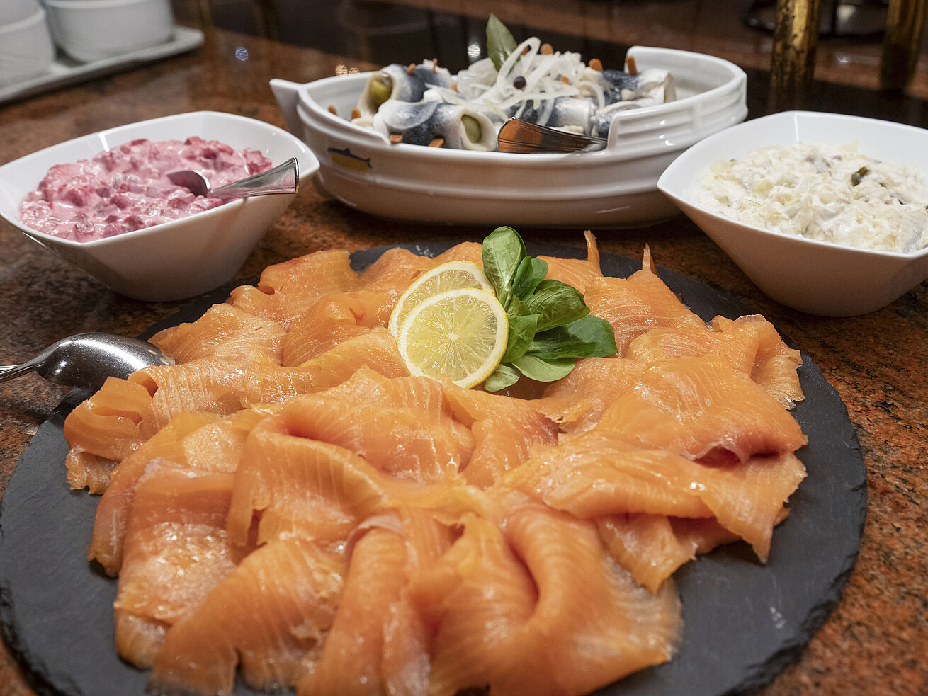Auswahl an geräuchertem Lachs und weiteren Fischspezialitäten am Frühstücksbuffet.