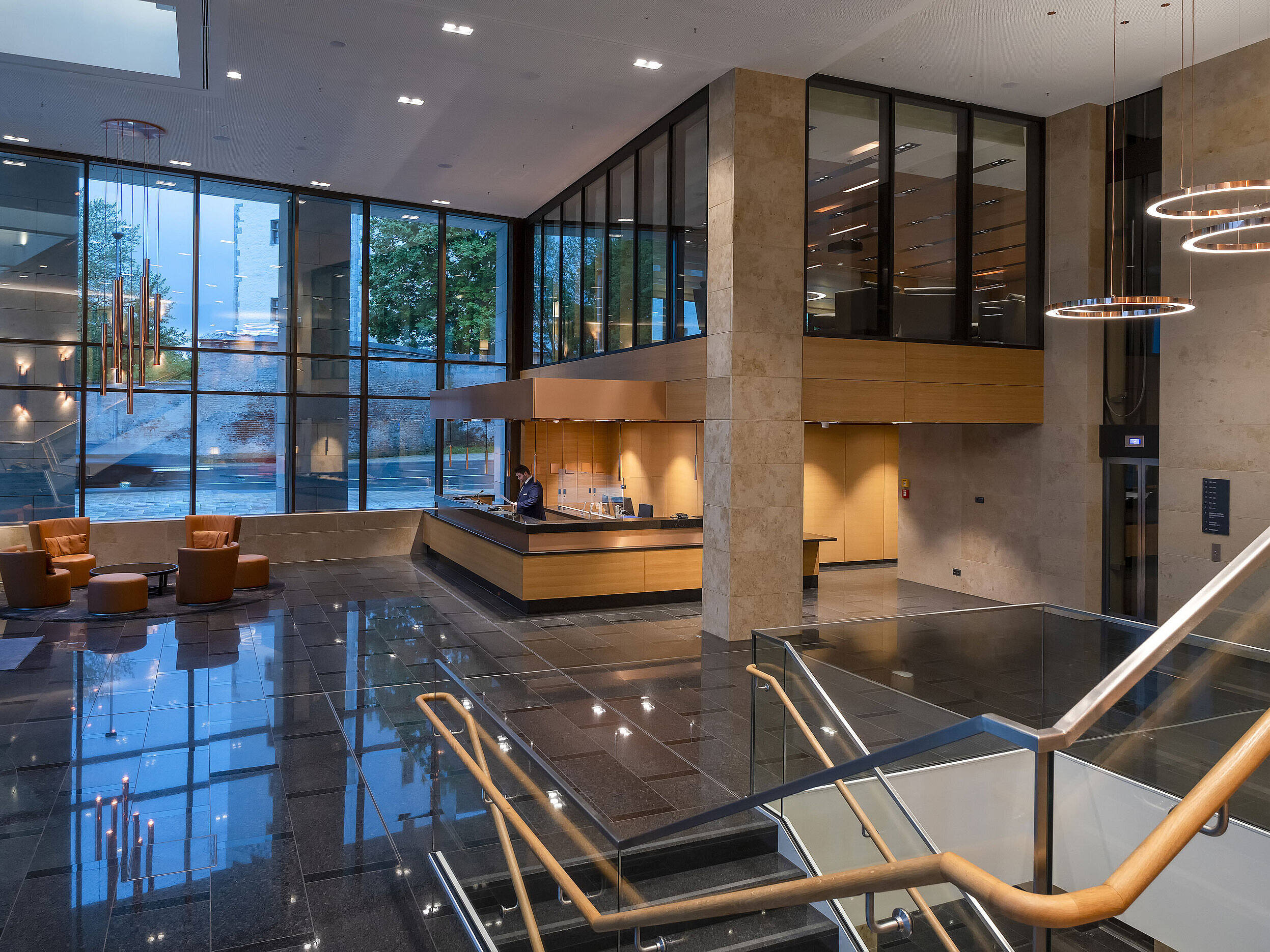 Die moderne Lobby des Maritim Hotel Ingolstadt mit hohen Glasfenstern, Rezeption und gemütlichen Sitzbereichen.