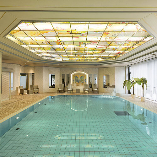 Innenpool mit Oberlicht und Liegestühlen im Wellnessbereich des Maritim Hotel Ulm