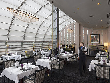 Helles Restaurant mit Servicekraft und stilvoller Einrichtung im Maritim Hotel München