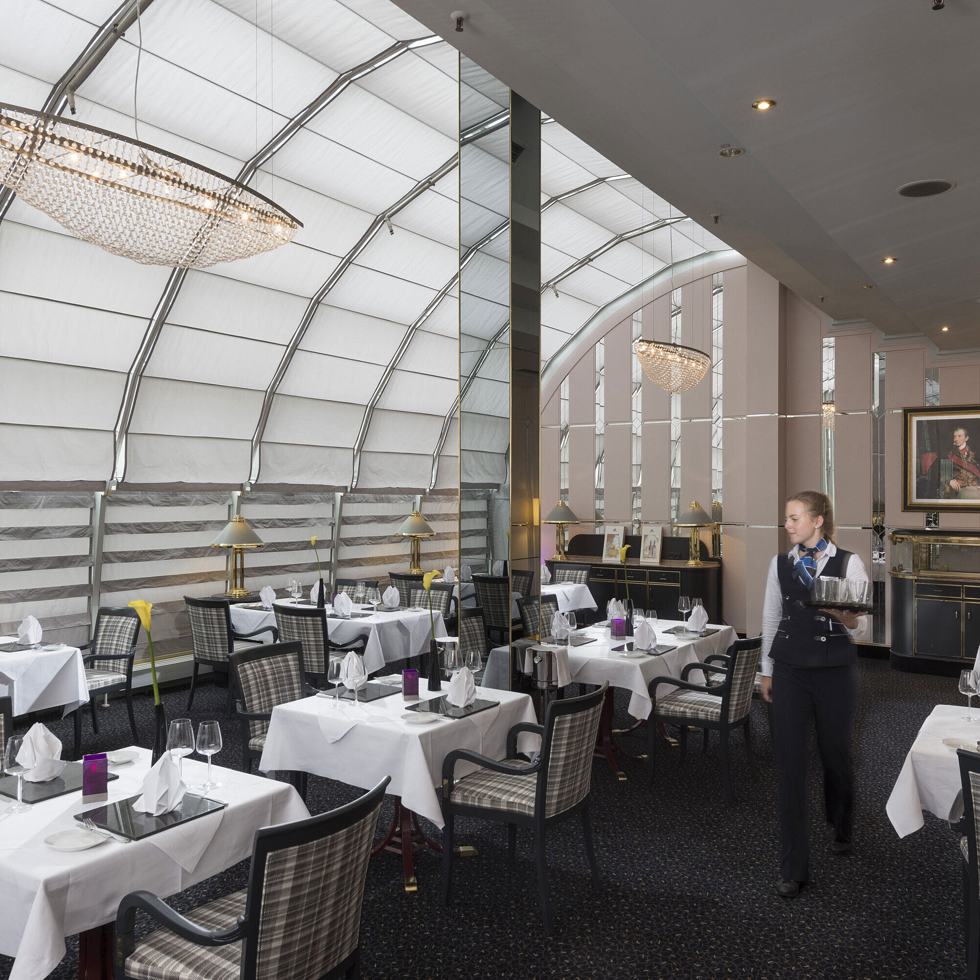 Helles Restaurant mit Servicekraft und stilvoller Einrichtung im Maritim Hotel München