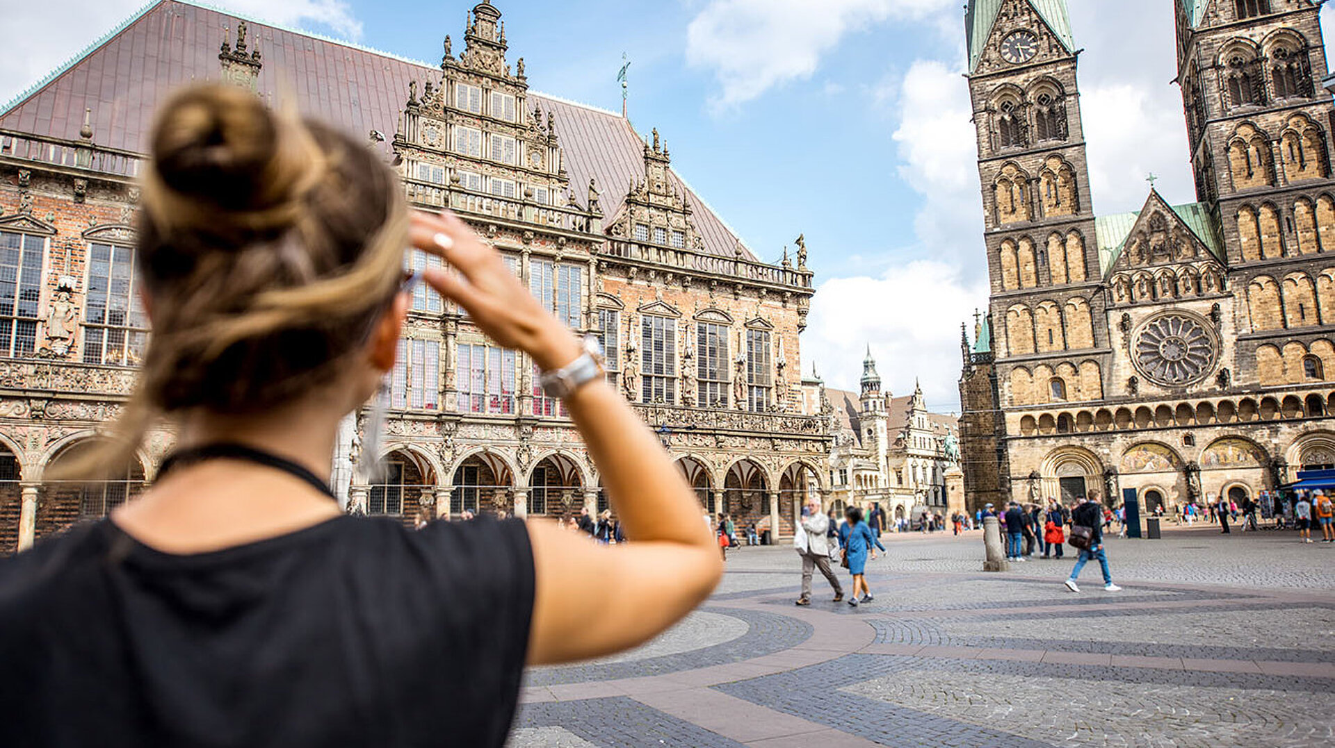 Touristin auf dem Bremer Marktplatz mit Blick auf Rathaus und Bremer Dom in der Altstadt
