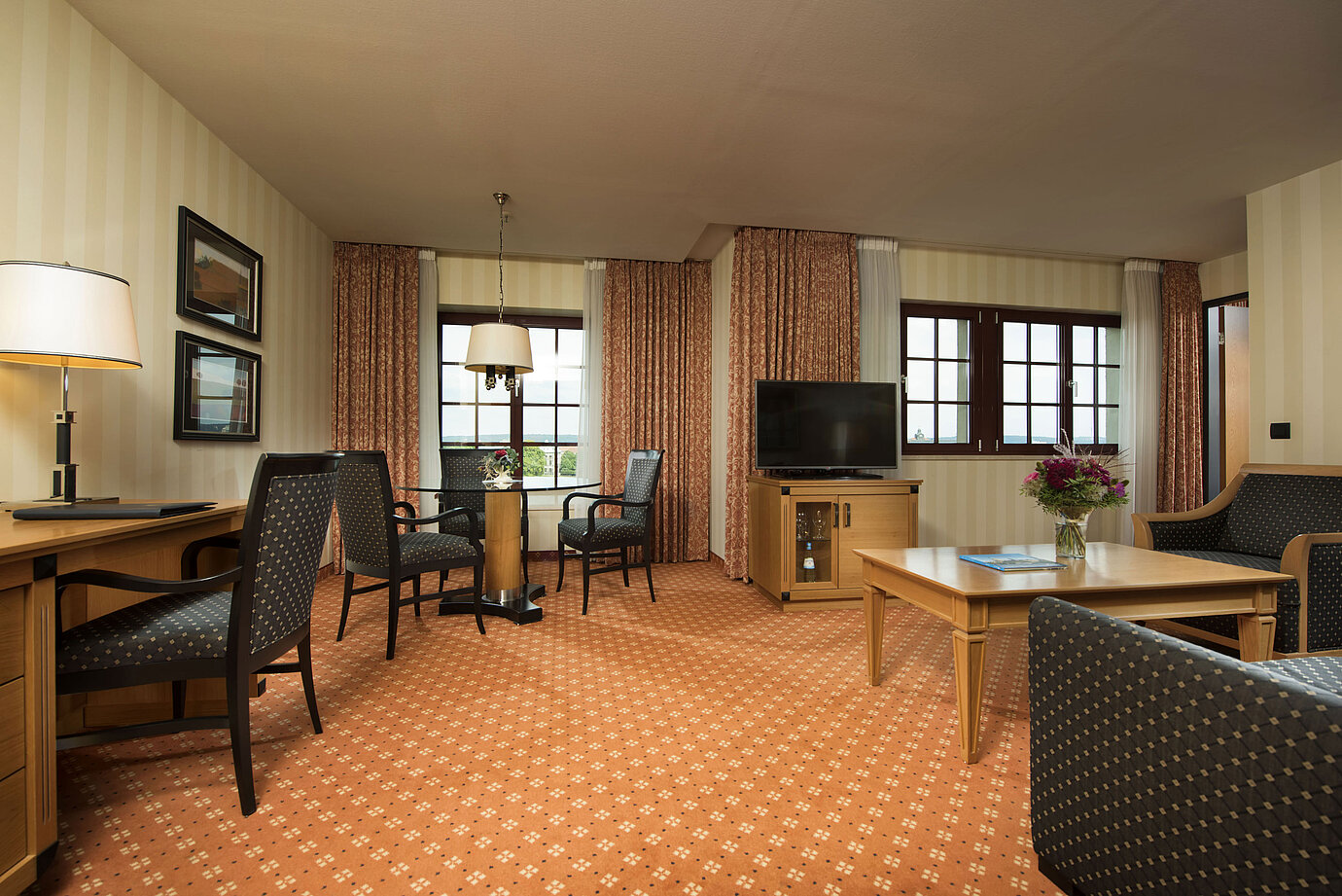 Junior Suite im Maritim Hotel Dresden mit stilvoller Sitzecke, großem Schreibtisch und moderner Einrichtung.