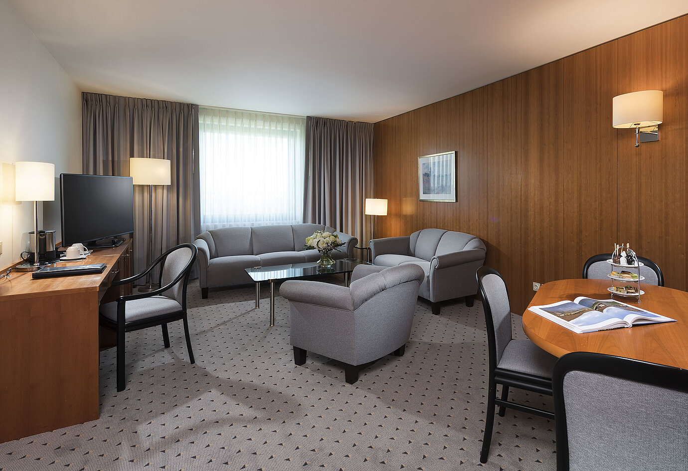 Junior Suite mit elegantem Wohnbereich, Sofa, Sesseln, Schreibtisch und TV im Maritim Hotel Hannover.