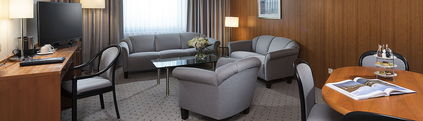 Junior Suite mit elegantem Wohnbereich, Sofa, Sesseln, Schreibtisch und TV im Maritim Hotel Hannover.
