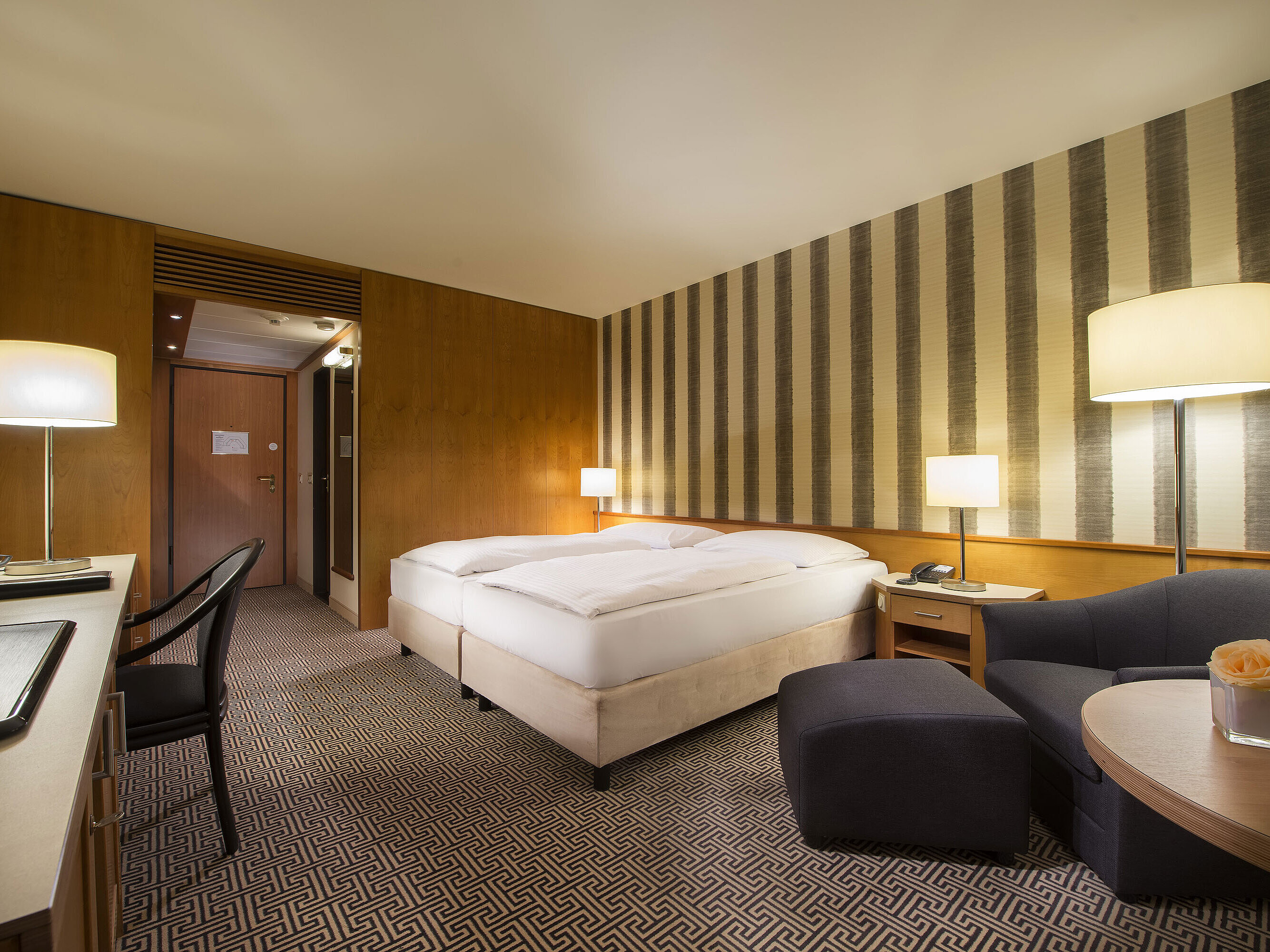 Helles Doppelzimmer mit weicher Beleuchtung und gemütlicher Sitzecke im Maritim Hotel Stuttgart