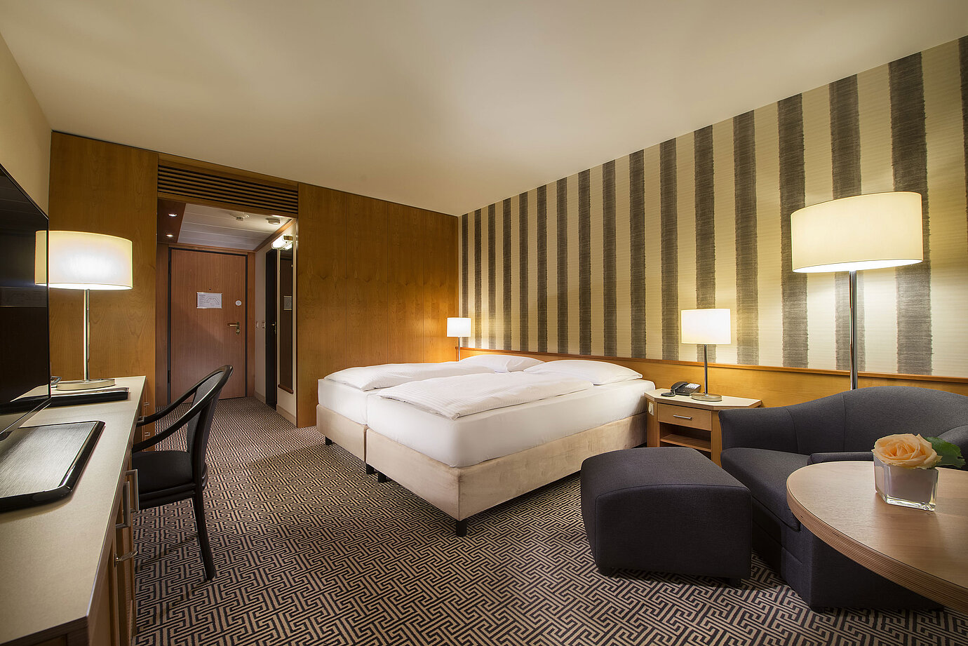 Helles Doppelzimmer mit weicher Beleuchtung und gemütlicher Sitzecke im Maritim Hotel Stuttgart