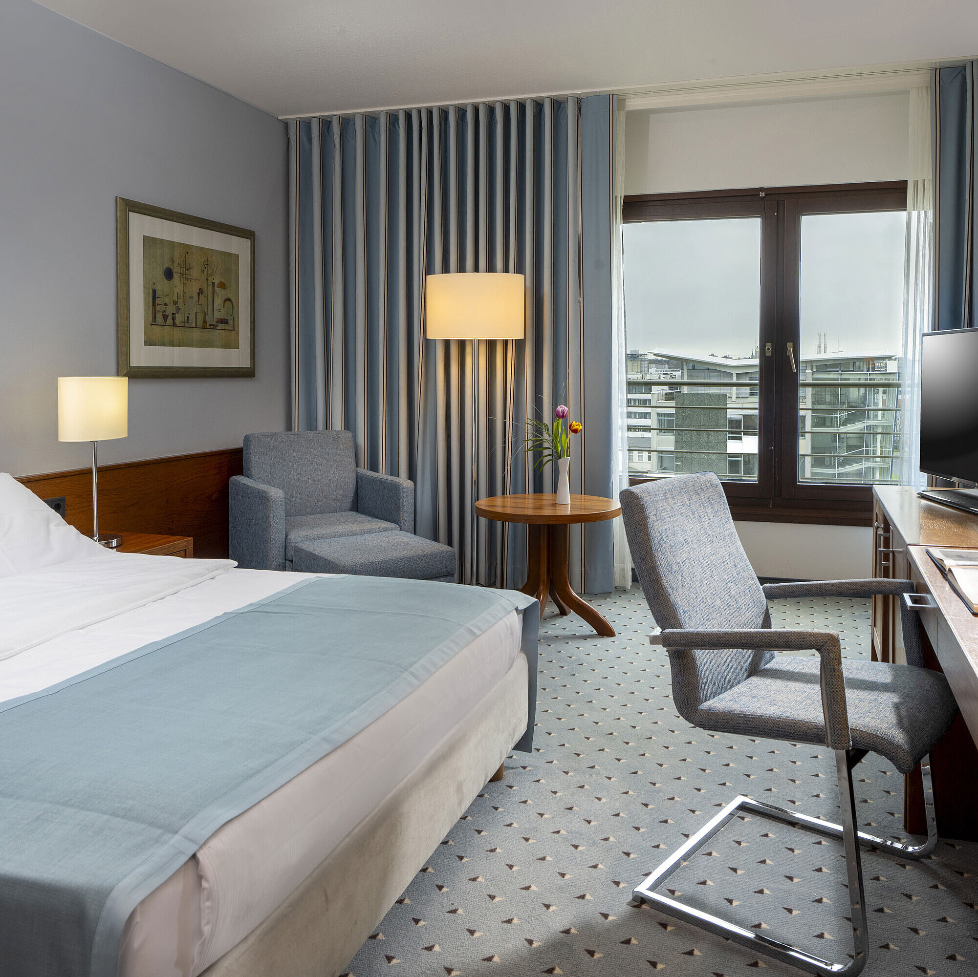 Comfort Zimmer Comfort-Doppelzimmer im Maritim Hotel Darmstadt mit gemütlicher Sitzecke, modernem Schreibtisch und Blick auf die Stadt.
