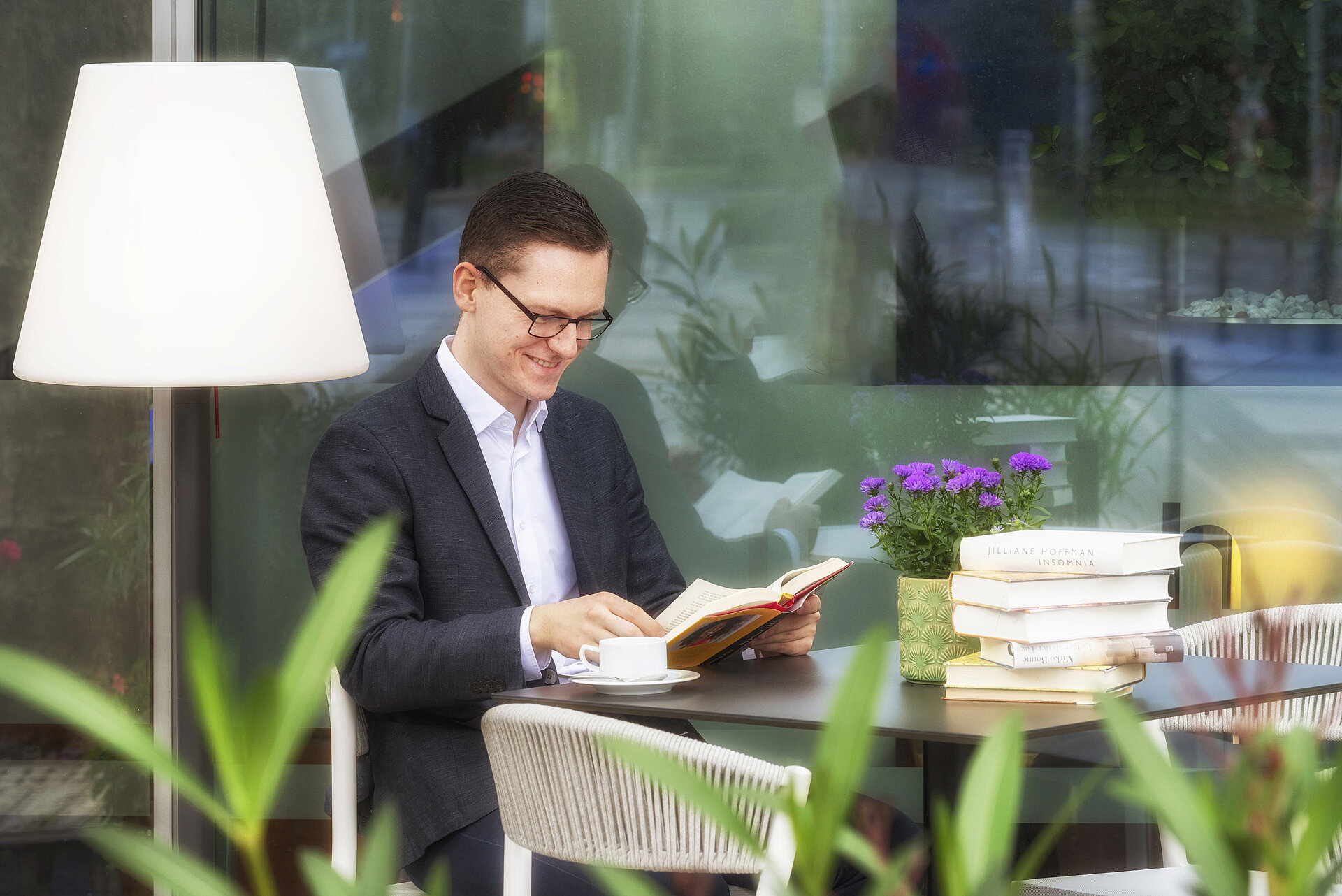 Terrasse Gast liest entspannt mit Kaffee und Büchern auf der Terrasse des Maritim Hotel Frankfurt bei angenehmer Atmosphäre.