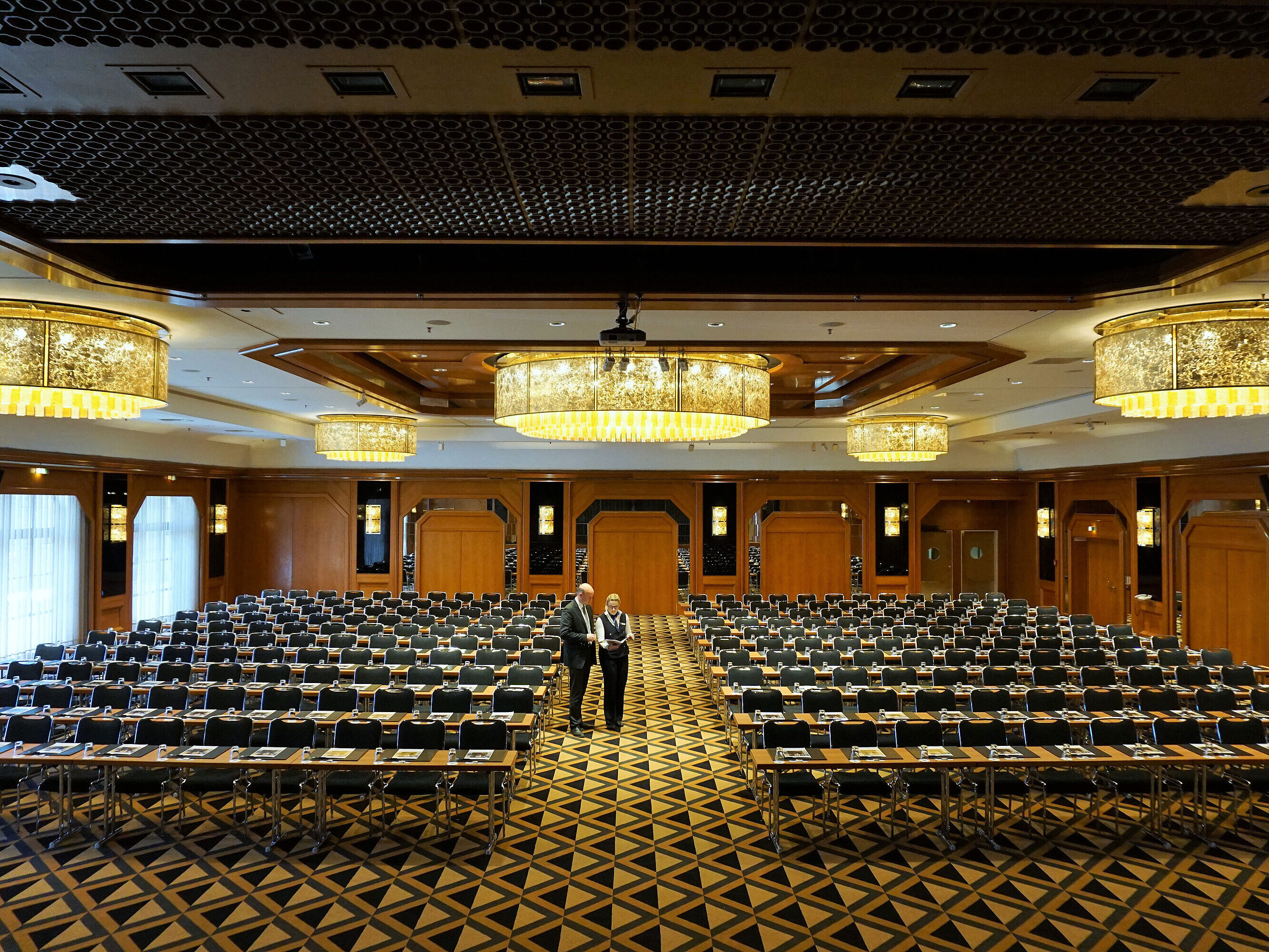 Eleganter Konferenzsaal im Maritim Hotel Königswinter mit moderner Bestuhlung und beeindruckenden Kronleuchtern.