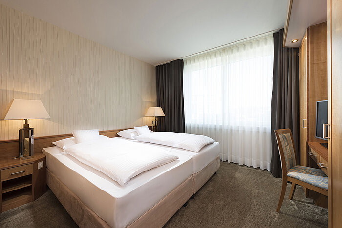 Helles Doppelzimmer im Maritim Hotel Stuttgart mit Schreibtisch, TV und gemütlicher Atmosphäre