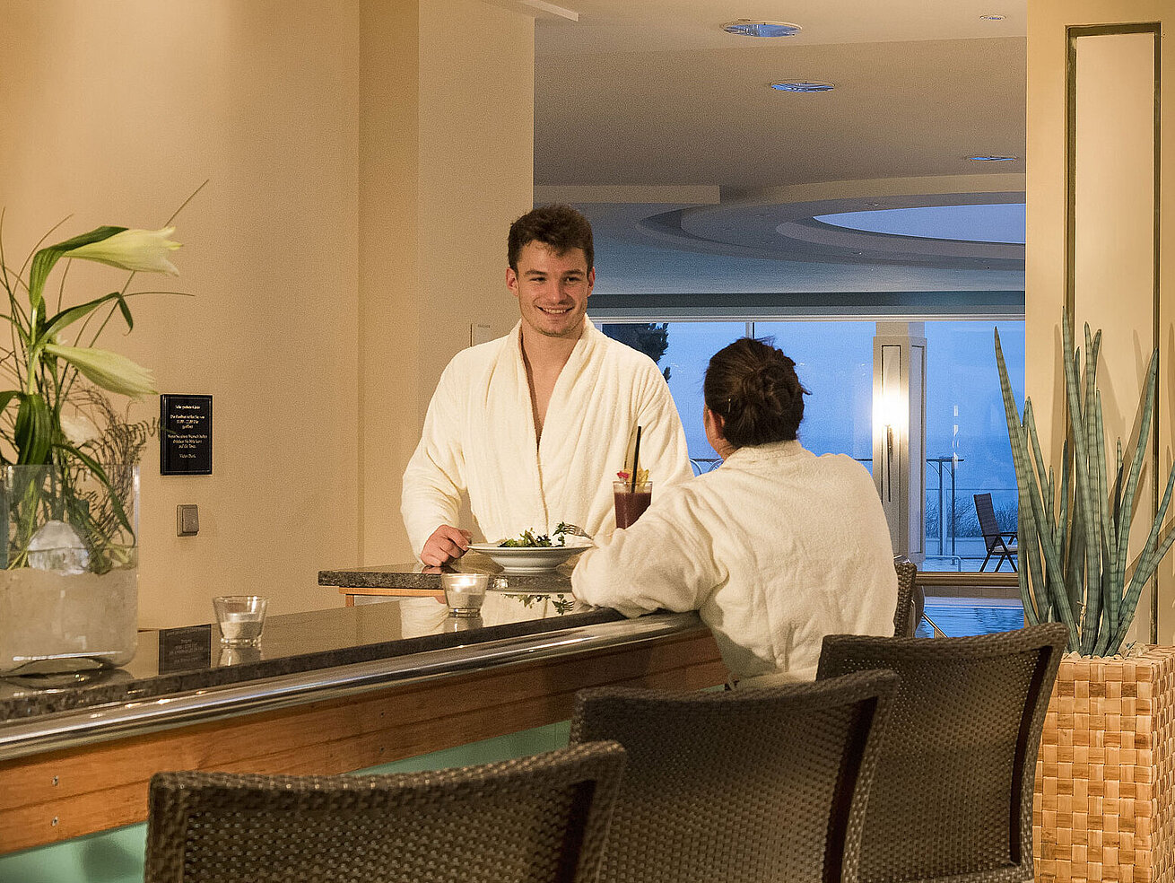 Wellnessbereich mit Pool und Gästen in Bademänteln im Maritim Seehotel Timmendorfer Strand.