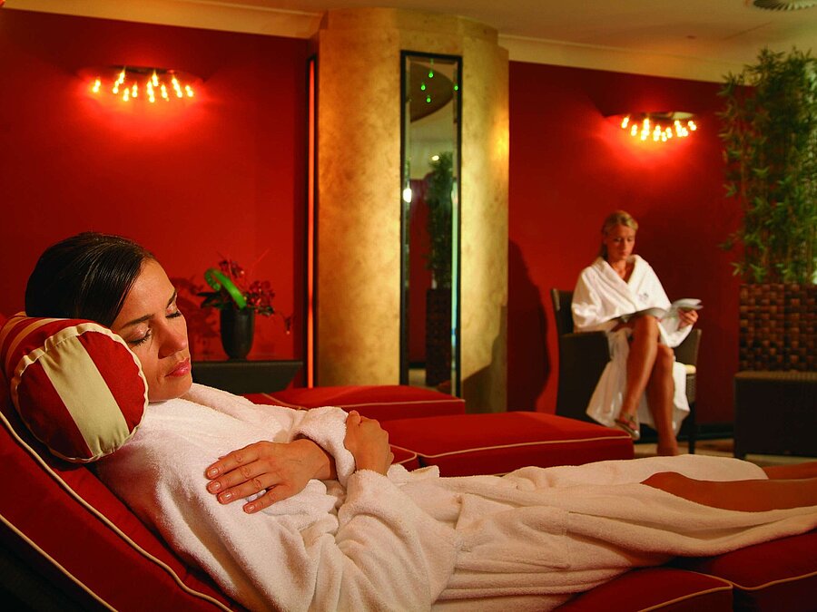 Entspannungsliegen im Wellnessbereich des Maritim Seehotel Timmendorfer Strand, mit zwei Frauen in Bademänteln.