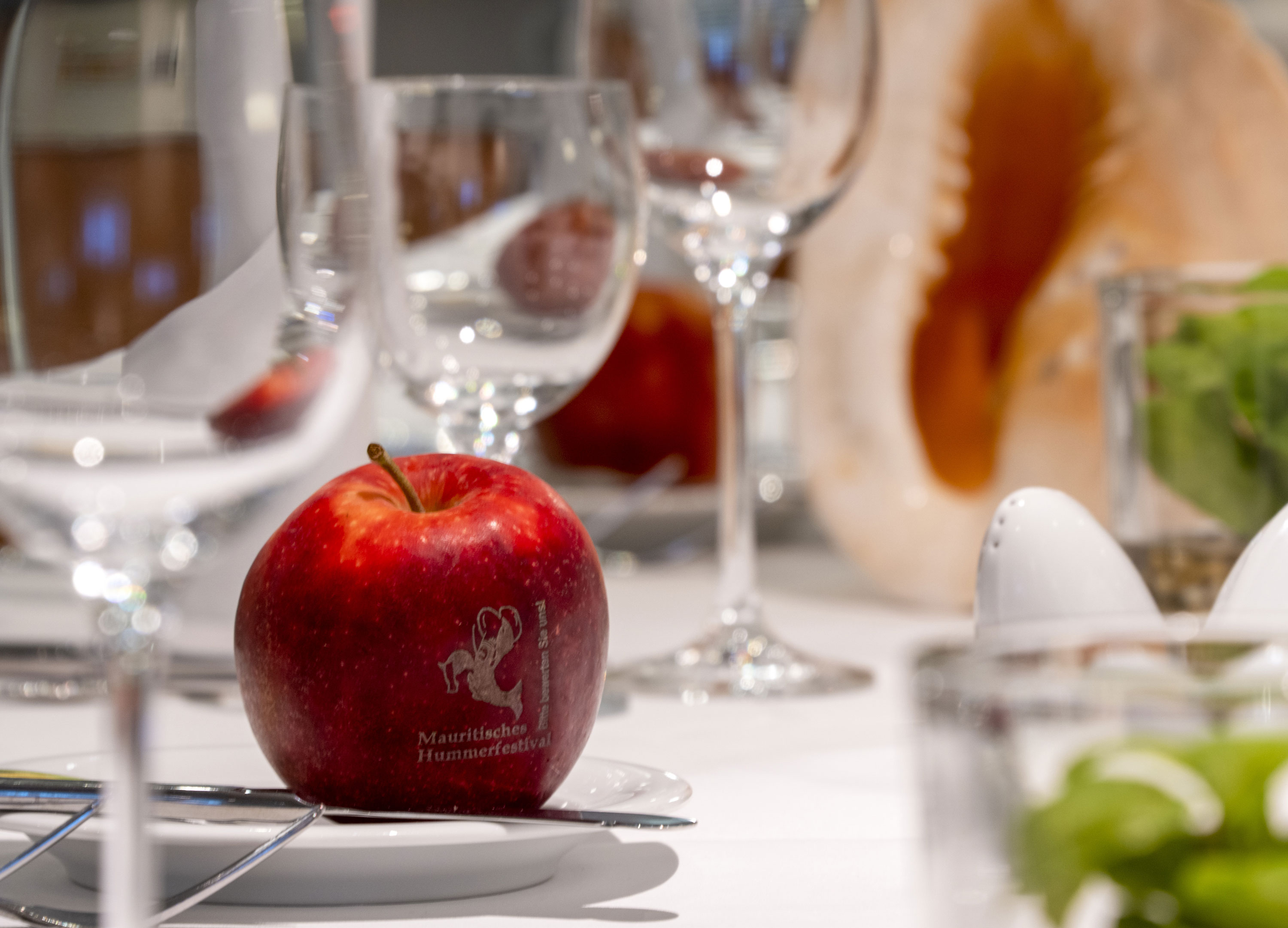 Dekorativ gestalteter Apfel auf einem Tisch im Maritim proArte Hotel Berlin, umgeben von Gläsern und dekorativen Elementen.