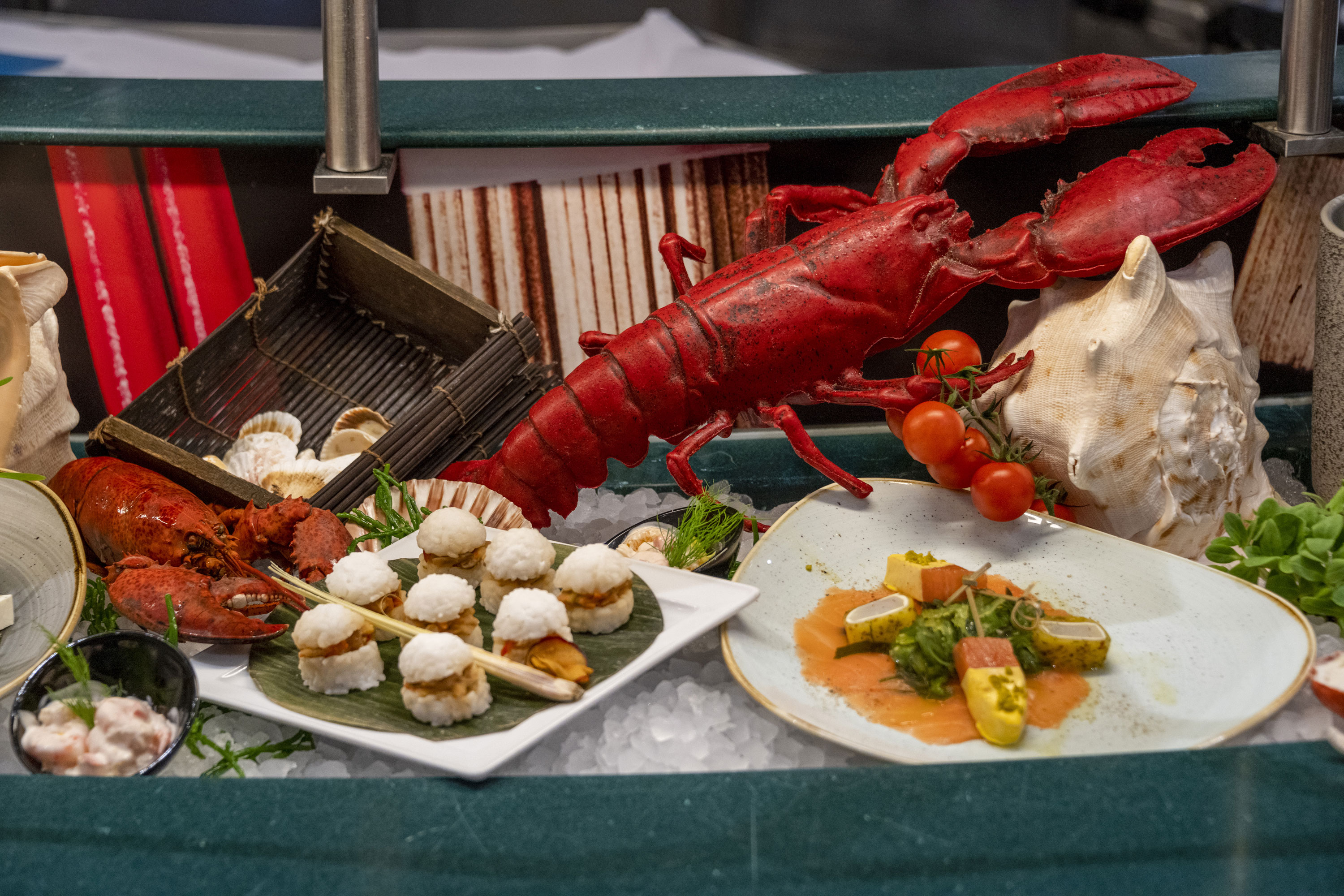 Hummer und Meeresfrüchte-Delikatessen am Buffet des Maritim proArte Hotel Berlin, dekoriert mit Tomaten und Muscheln.