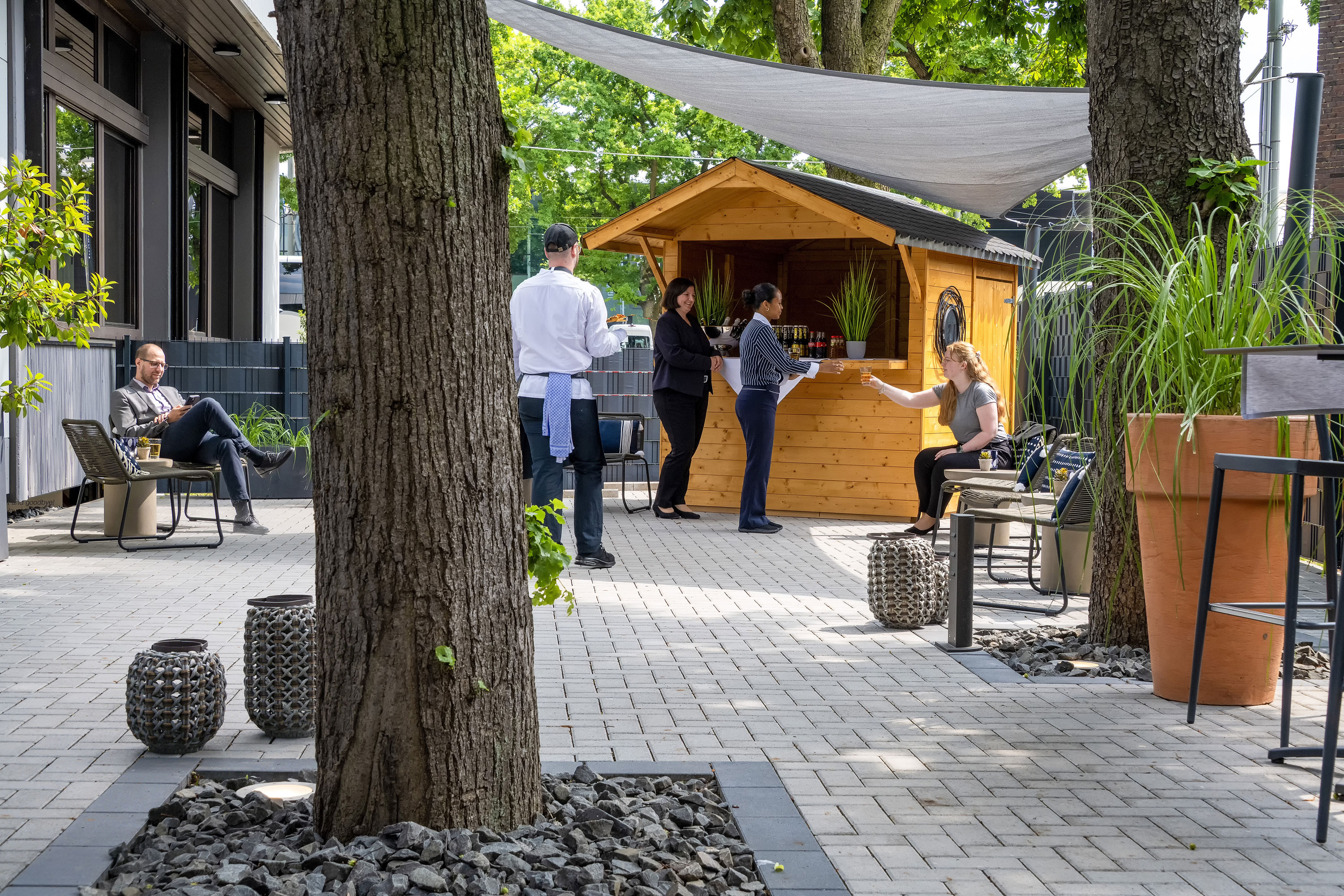 Außenterrasse Gäste bei einem Empfang an einer Holzhütte auf der großzügigen Außenterrasse des Maritim Hotel Darmstadt