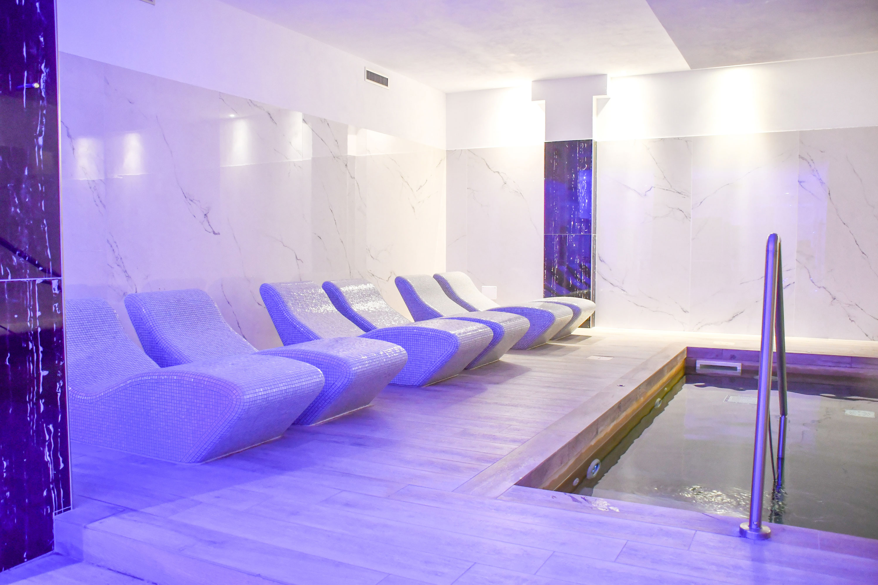 Entspannungsbereich mit beheiztem Becken und Liegen im Spa des Maritim Resort Calabria