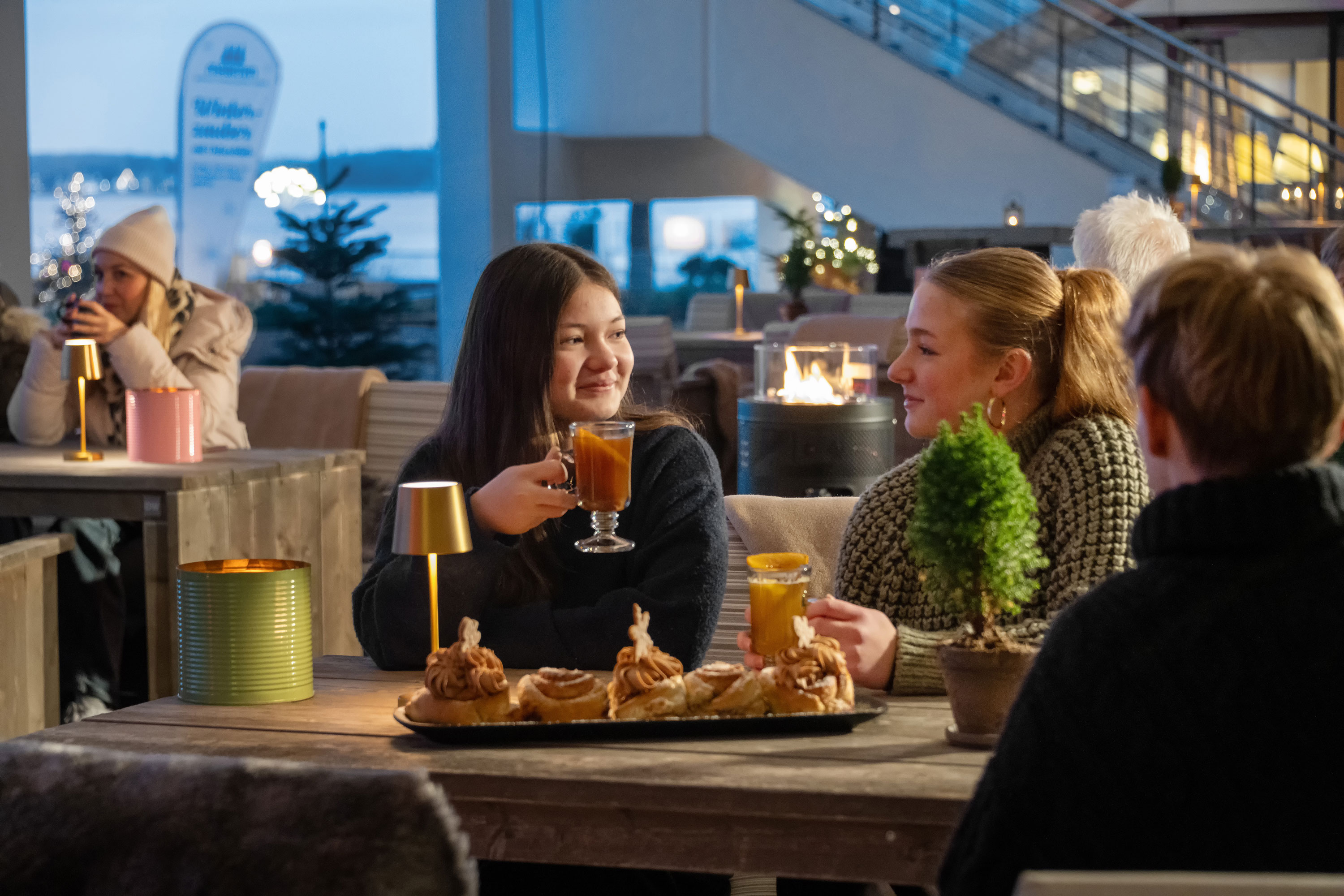 Winterzauber an der Ostsee Gäste genießen winterliche Atmosphäre mit Getränken und Dekoration in einem Restaurant an der Ostsee.